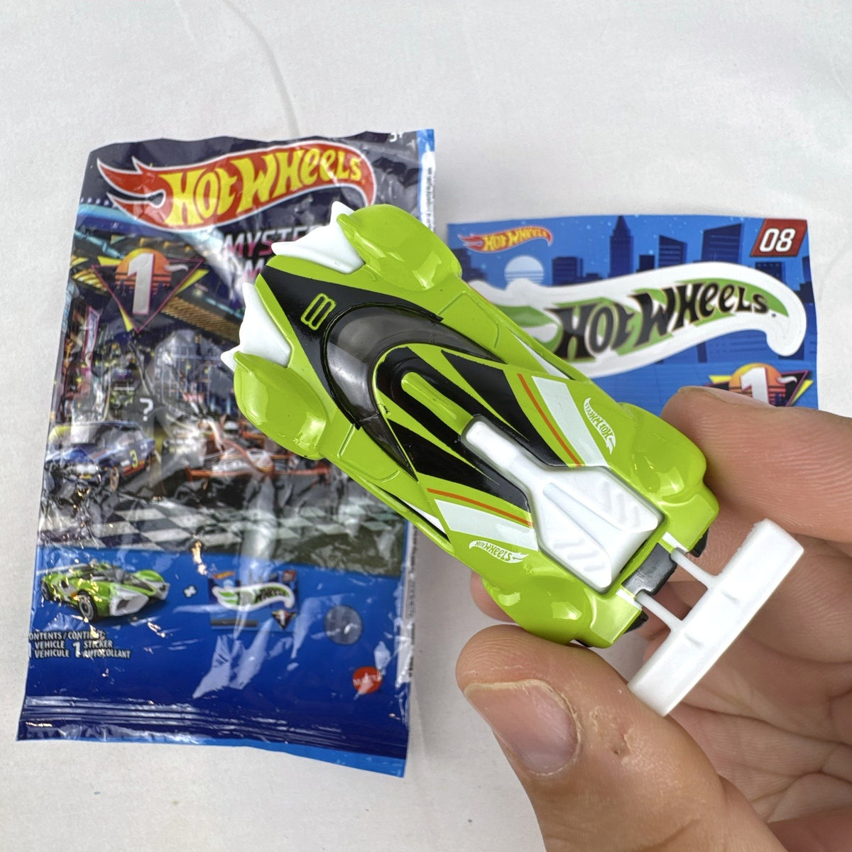 Hot Wheels 2021 Mystery Models Series 1 Mach Speeder #08 diecast car in bright lime green with matching sticker card.