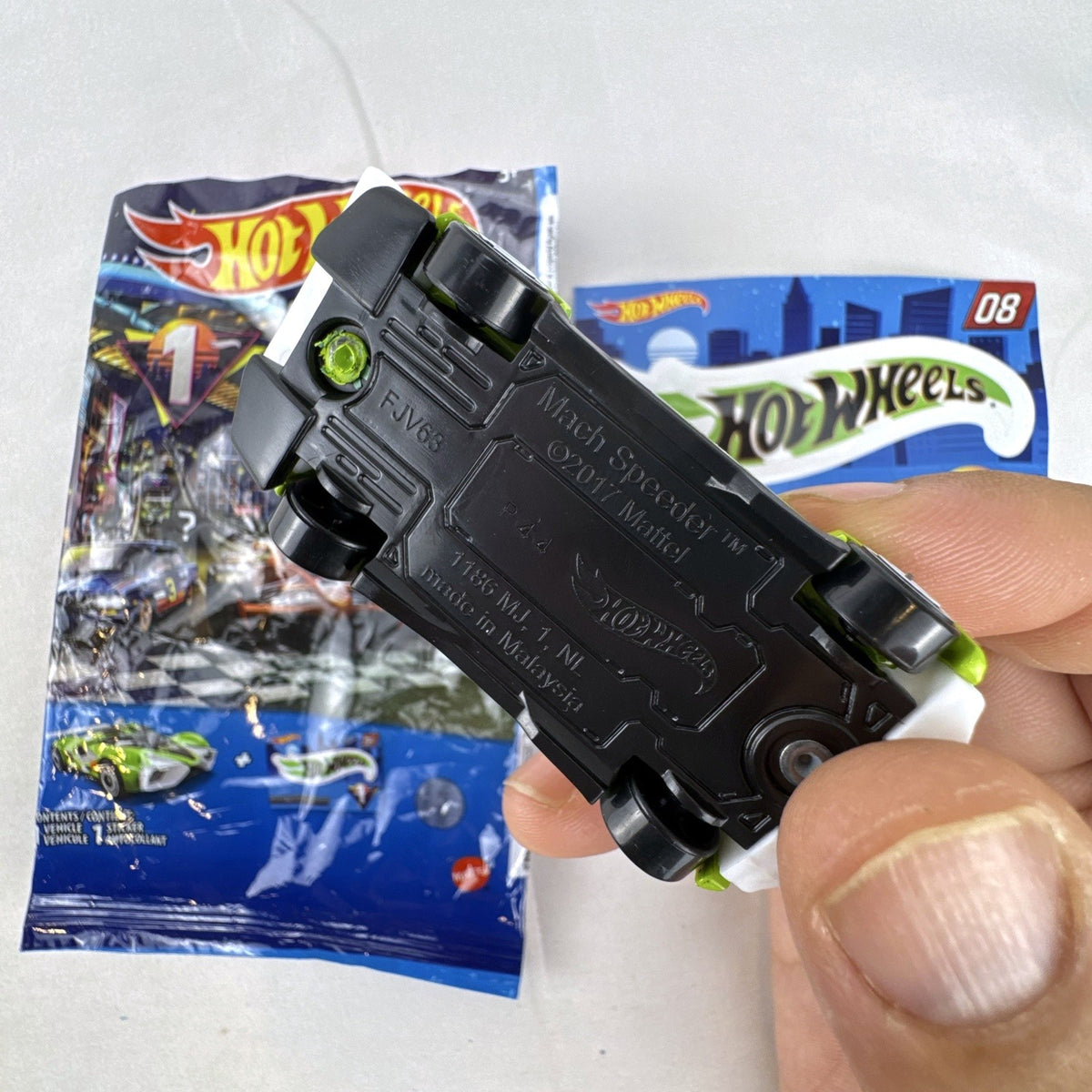 Hot Wheels 2021 Mystery Models Series 1 Mach Speeder #08 diecast car in bright lime green with matching sticker card.