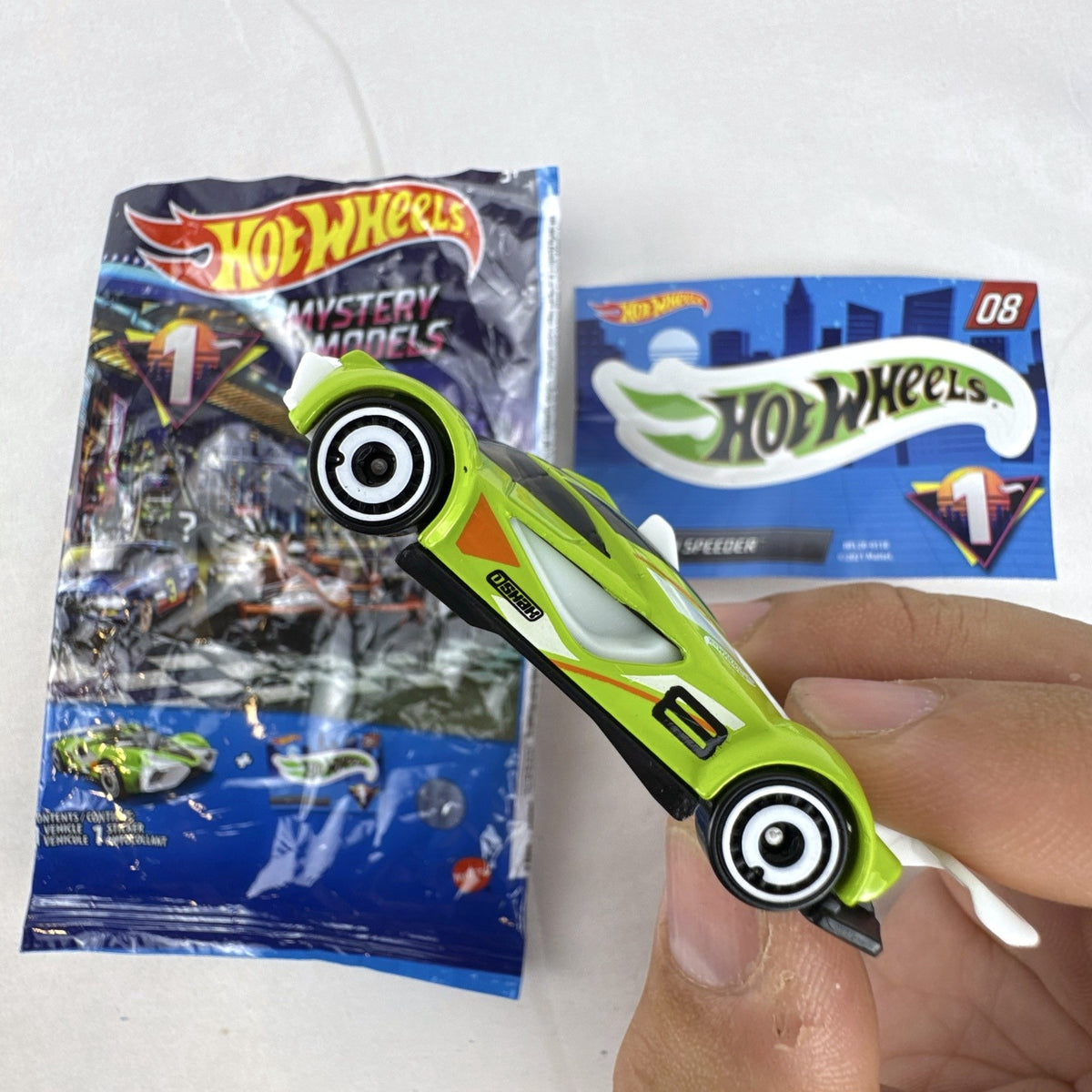 Hot Wheels 2021 Mystery Models Series 1 Mach Speeder #08 diecast car in bright lime green with matching sticker card.