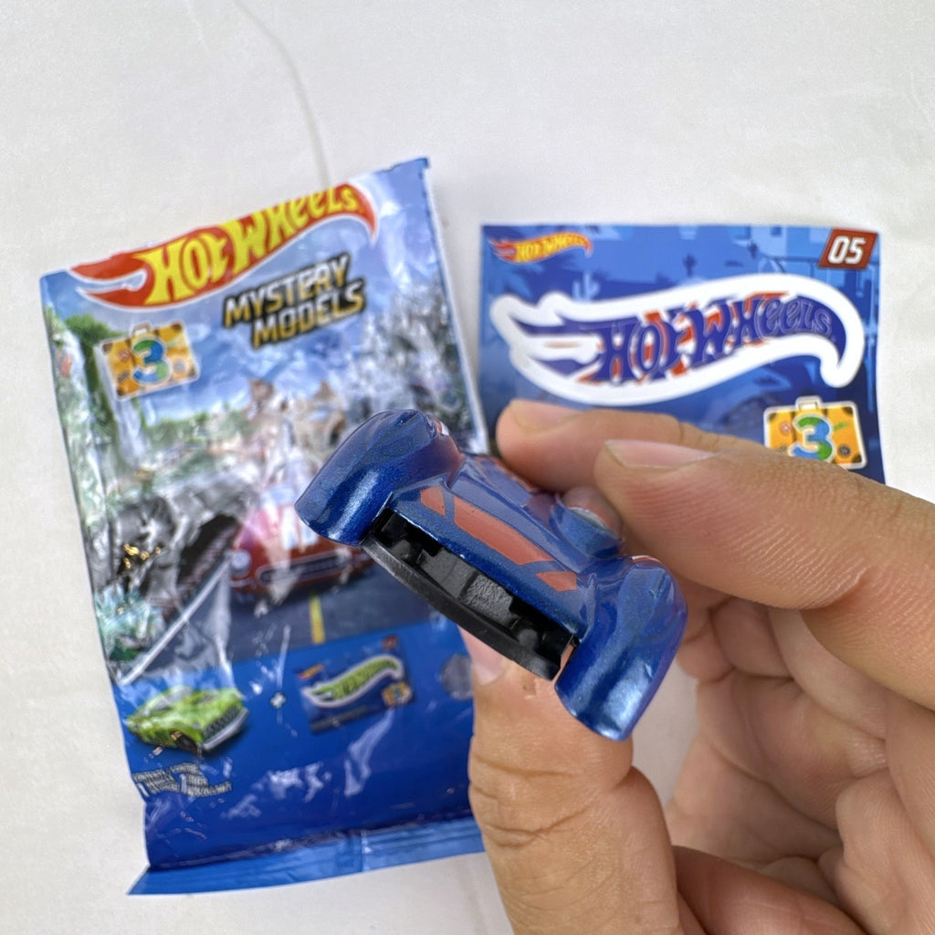 Hot Wheels Monoposto Mystery Models Series 3 #05 blue diecast car with Union Jack livery, original bag, and sticker card.