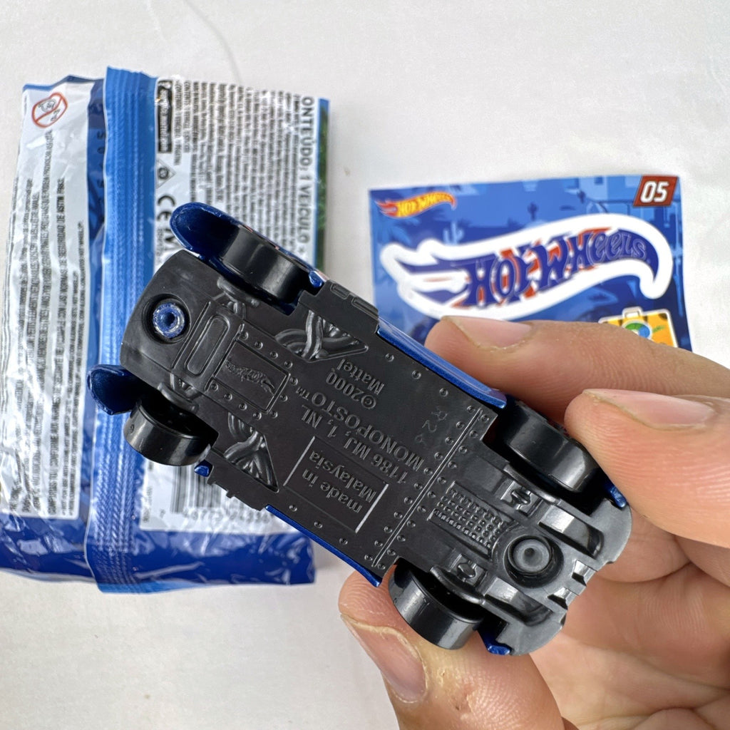 Hot Wheels Monoposto Mystery Models Series 3 #05 blue diecast car with Union Jack livery, original bag, and sticker card.
