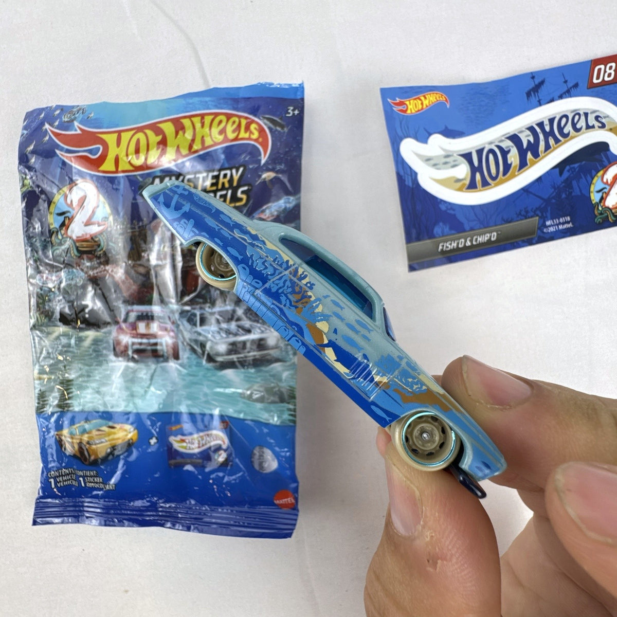 Hot Wheels Fish'd & Chip'd 1:64 scale diecast car in light blue with Union Jack roof graphic and bonus sticker.