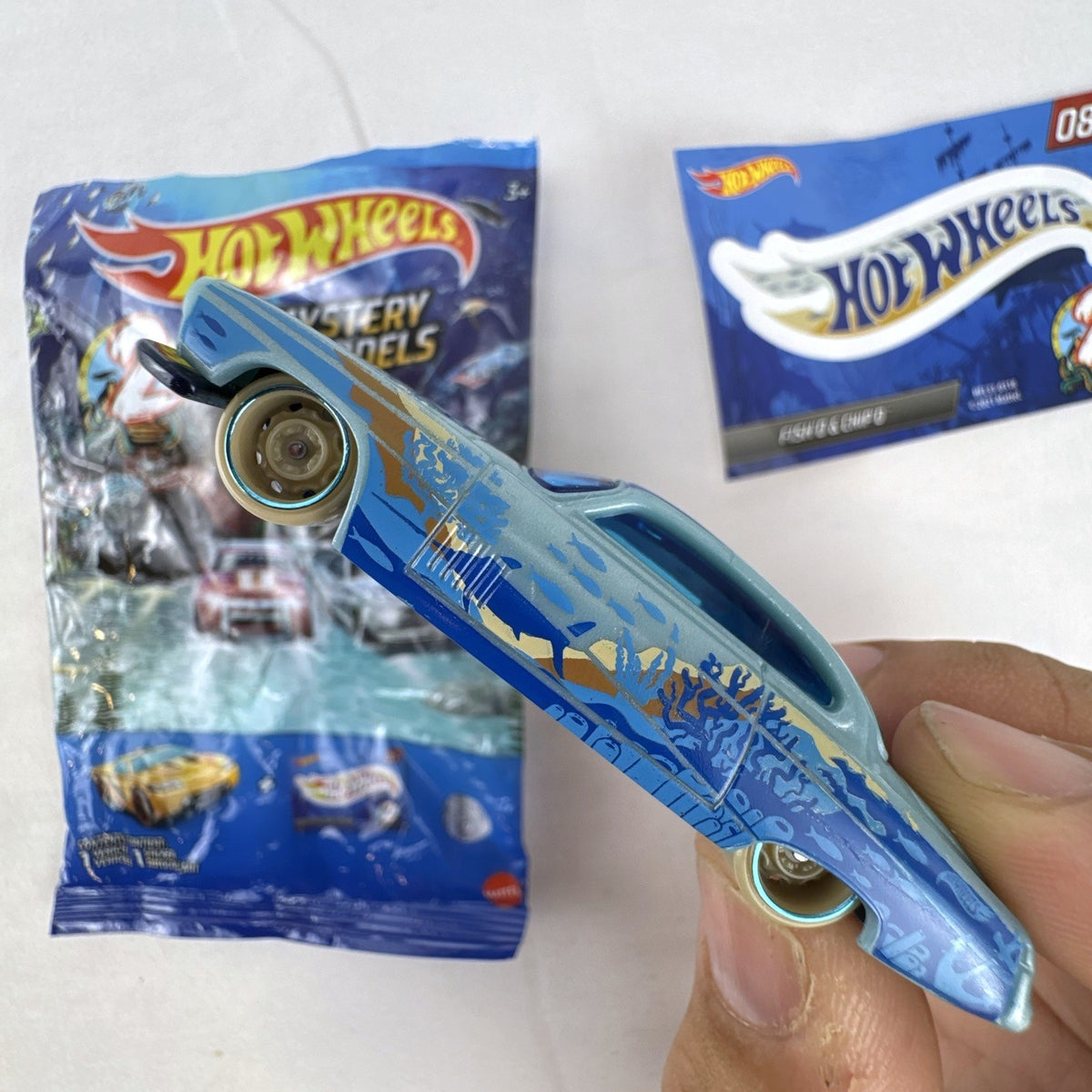 Hot Wheels Fish'd & Chip'd 1:64 scale diecast car in light blue with Union Jack roof graphic and bonus sticker.
