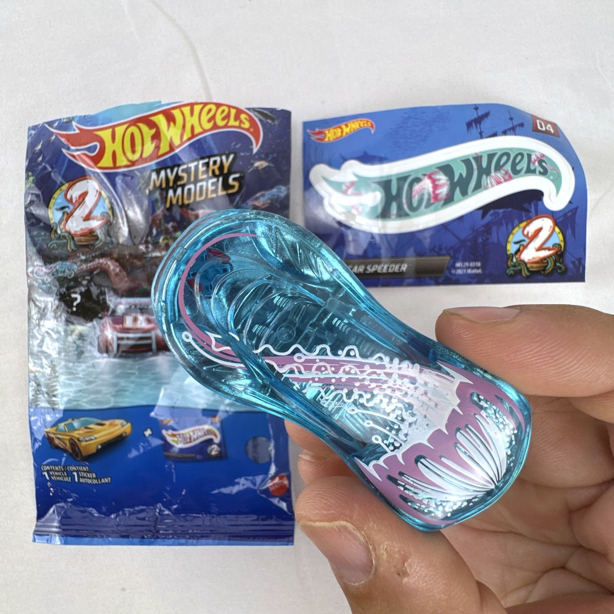 Hot Wheels Clear Speeder translucent blue diecast car Series 2 Mystery Model 04 with sticker sheet and packaging