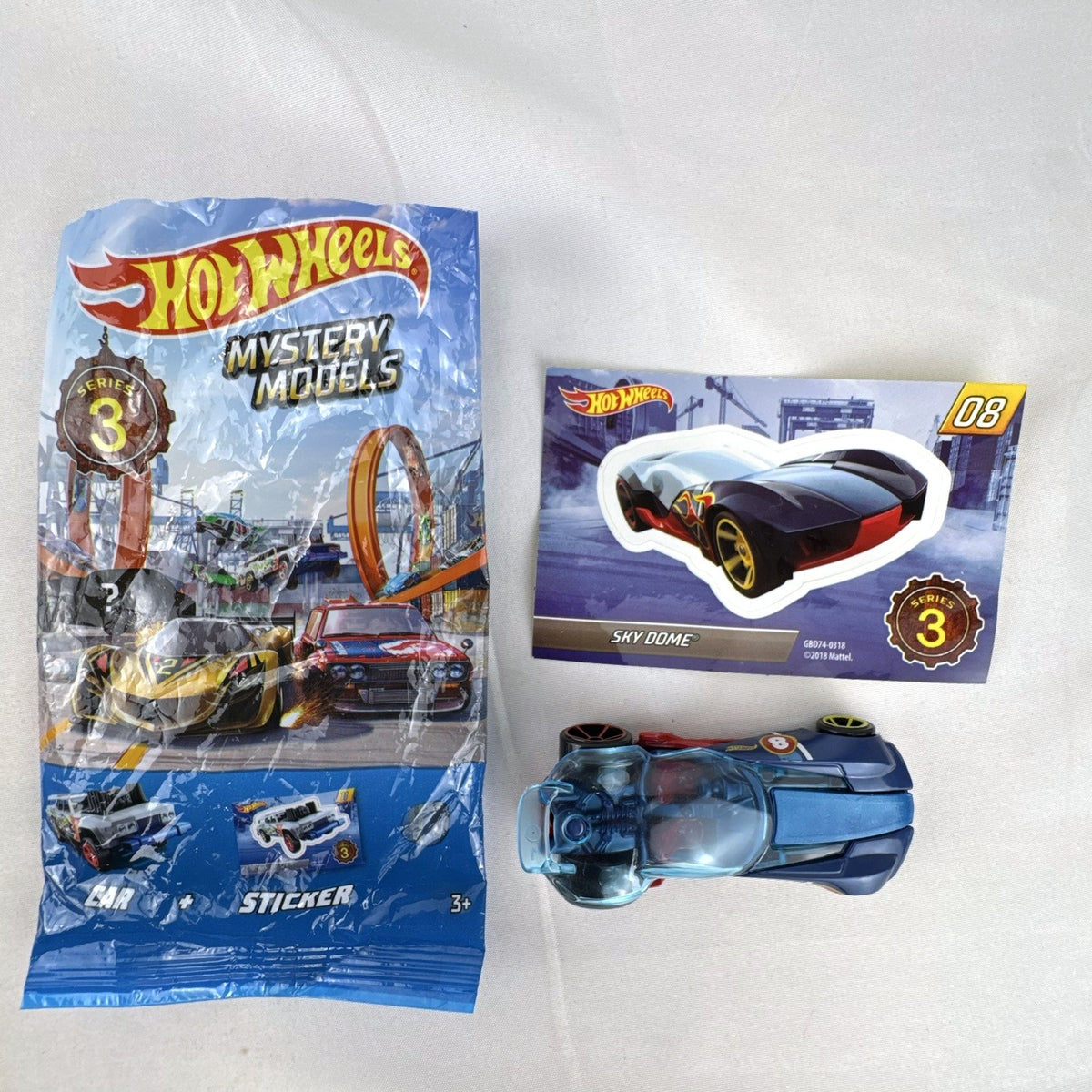 Hot Wheels Sky Dome 1:64 scale diecast car in dark blue with original Mystery Models Series 3 sticker card and bag.