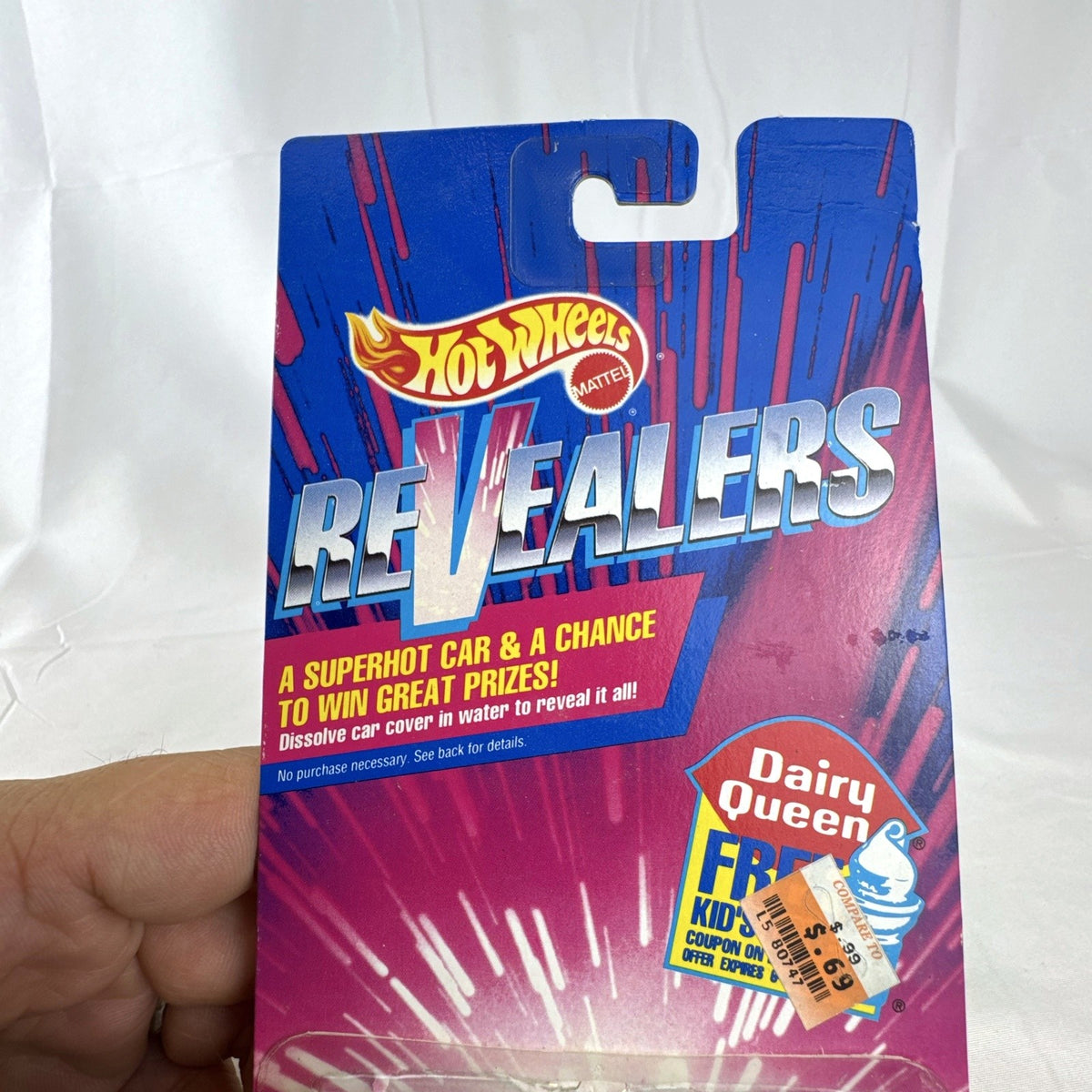 Sealed 1993 Hot Wheels Revealers 1:64 diecast car on Dairy Queen promo card with purple water-dissolvable cover