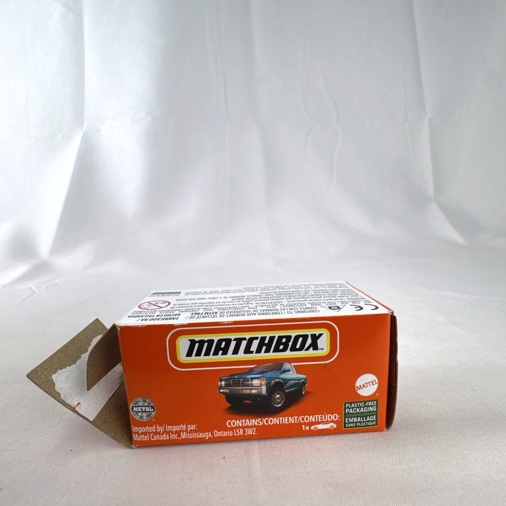 Matchbox 1:64 scale 1995 Nissan Hardbody D21 diecast pickup truck in metallic teal blue with original Power Grabs box