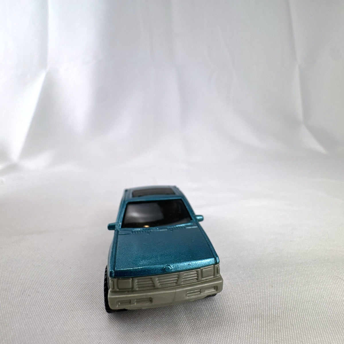 Matchbox 1:64 scale 1995 Nissan Hardbody D21 diecast pickup truck in metallic teal blue with original Power Grabs box