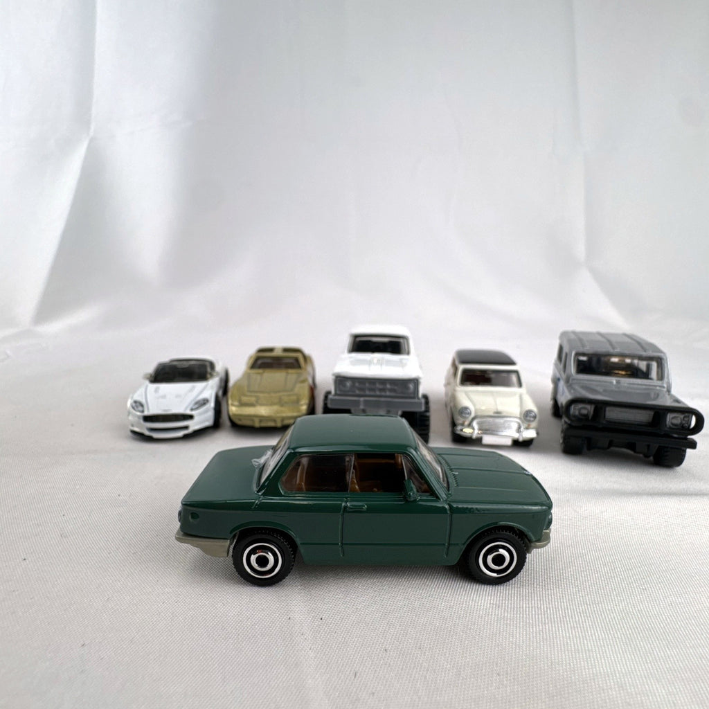 Set of six loose Matchbox diecast vehicles including BMW 2002, Corvette, Mini Cooper, Aston Martin, Dodge, and Land Rover