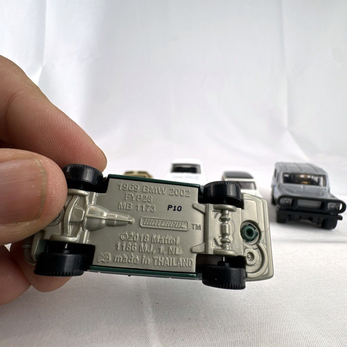 Set of six loose Matchbox diecast vehicles including BMW 2002, Corvette, Mini Cooper, Aston Martin, Dodge, and Land Rover