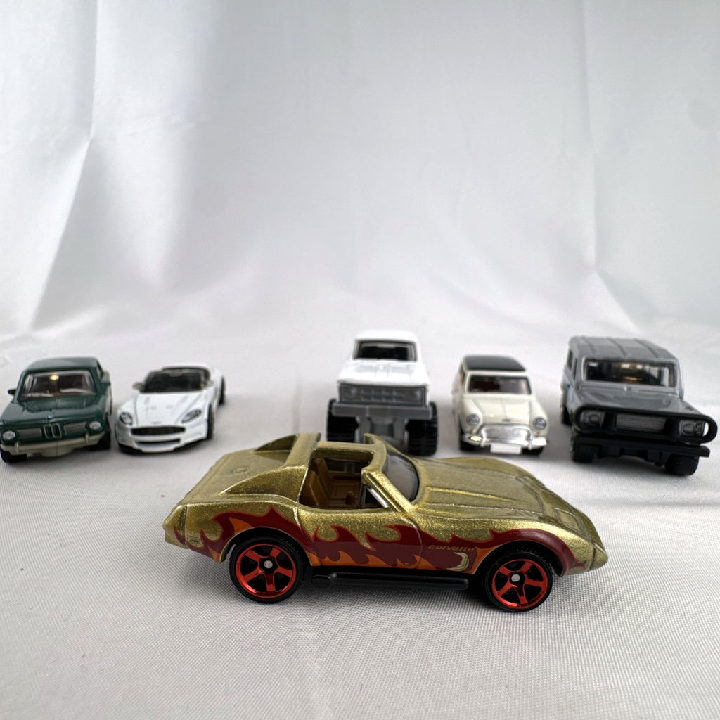 Set of six loose Matchbox diecast vehicles including BMW 2002, Corvette, Mini Cooper, Aston Martin, Dodge, and Land Rover