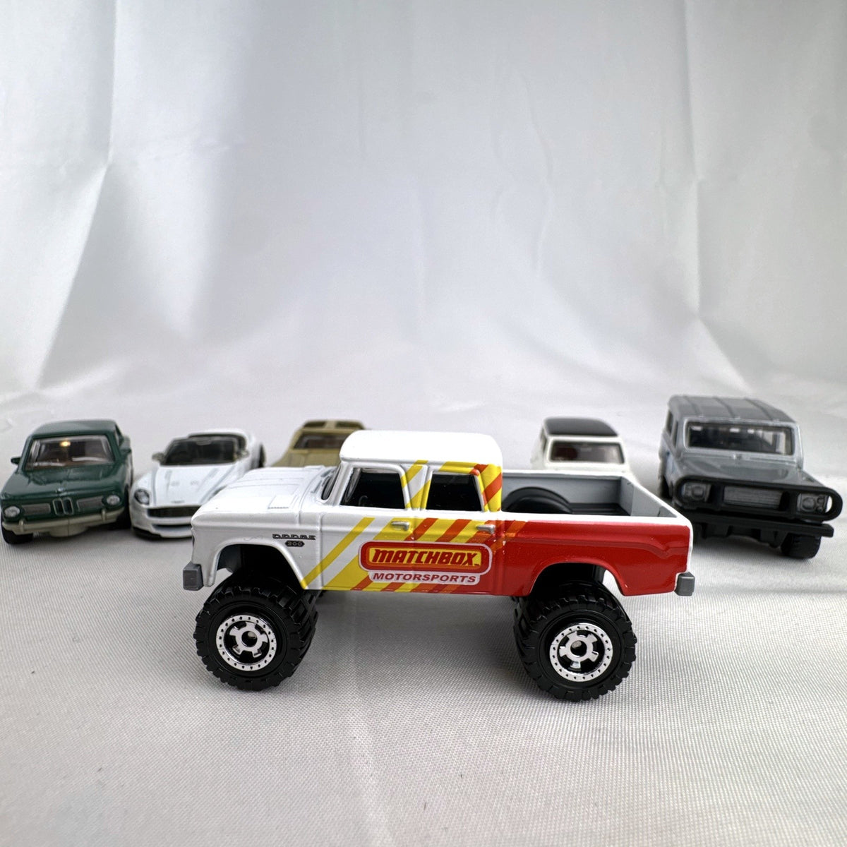 Set of six loose Matchbox diecast vehicles including BMW 2002, Corvette, Mini Cooper, Aston Martin, Dodge, and Land Rover