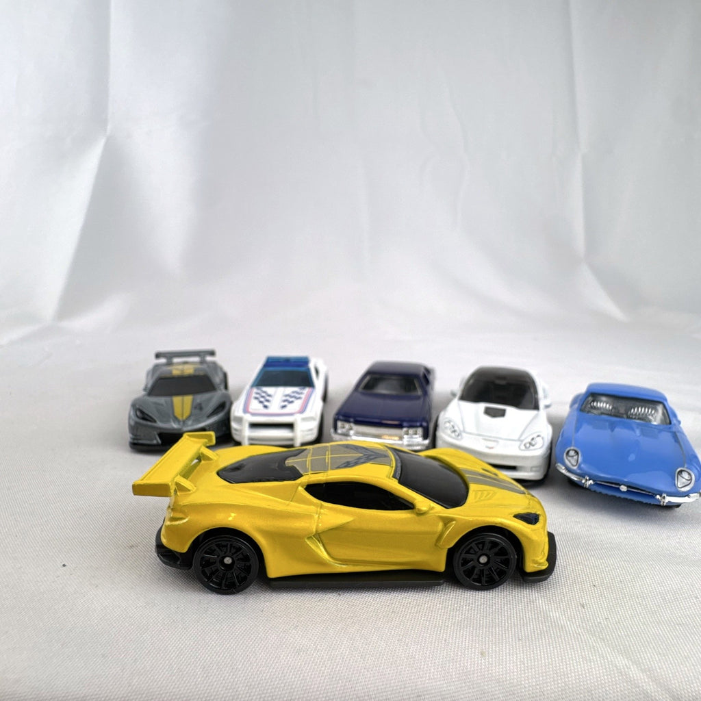 Set of 6 loose 1:64 scale Hot Wheels and Matchbox diecast cars including Corvette C8.R, Mustang, Caprice, and Jaguar E-Type