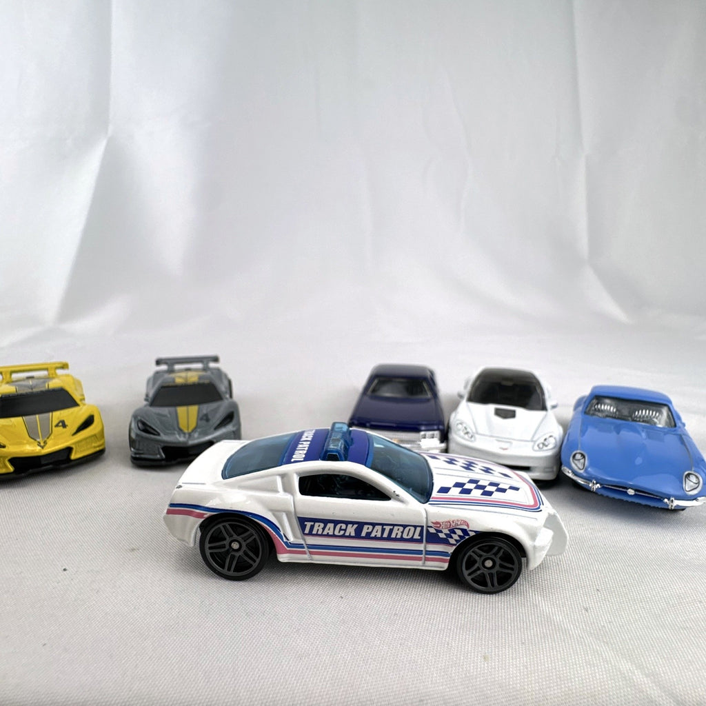 Set of 6 loose 1:64 scale Hot Wheels and Matchbox diecast cars including Corvette C8.R, Mustang, Caprice, and Jaguar E-Type
