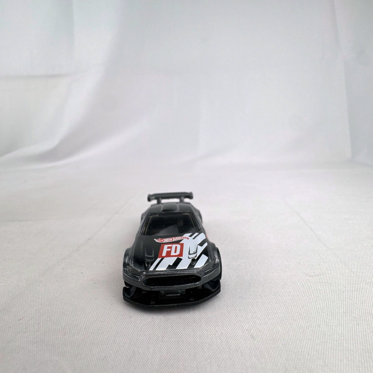 Hot Wheels 1:64 Custom '18 Ford Mustang GT Formula Drift diecast car in dark gray with red chassis base