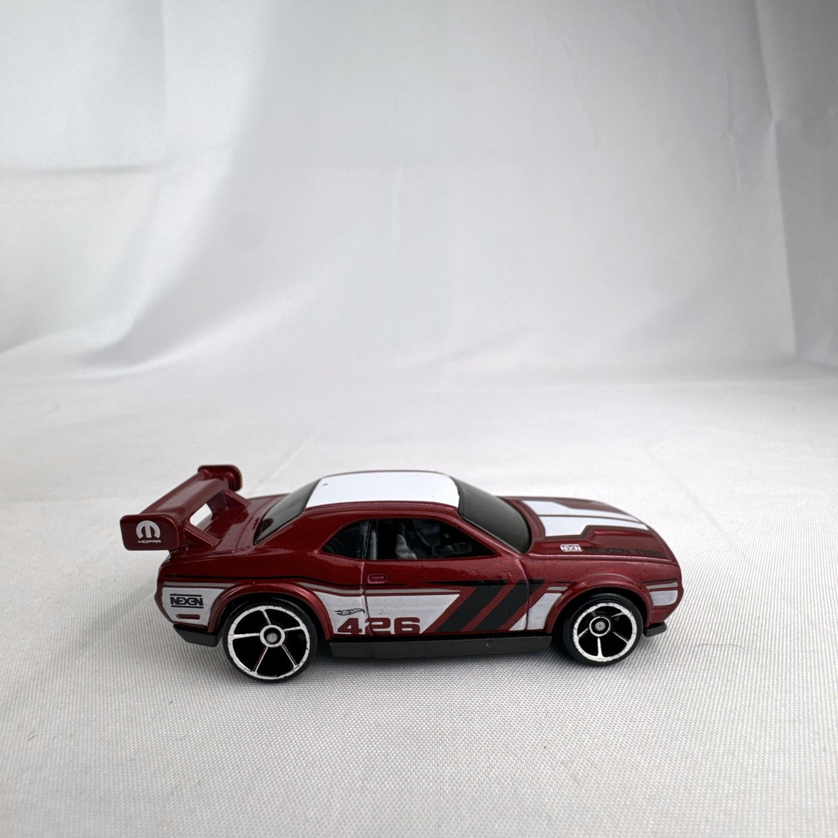 Hot Wheels 1:64 diecast Dodge Challenger Drift Car in metallic red with Mopar and Nexen Tire graphics