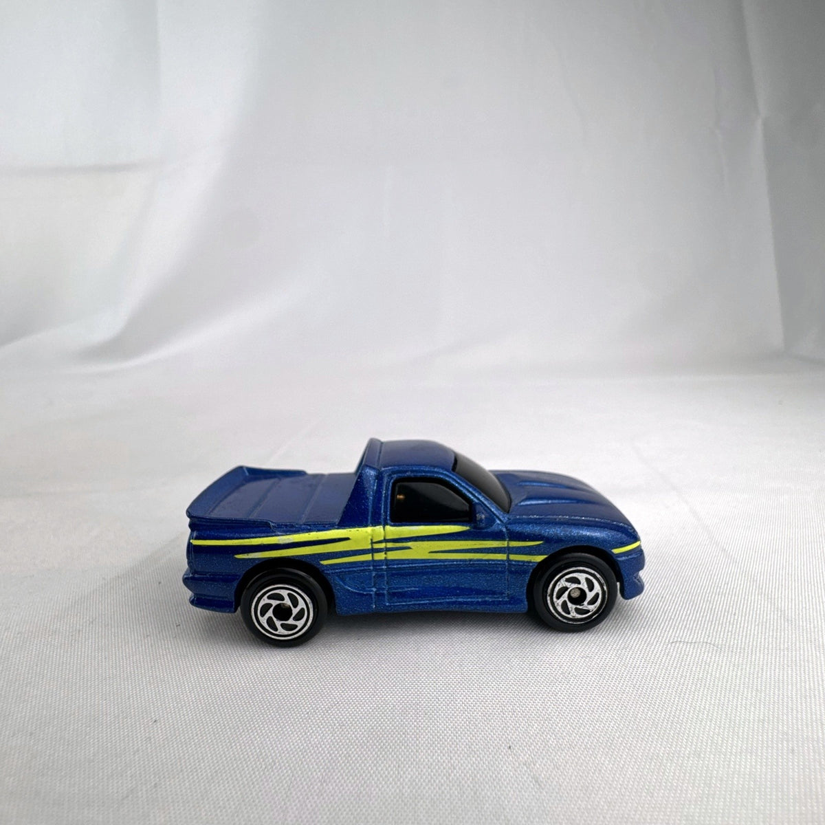 Matchbox 1995 The Buster 1:64 scale custom diecast pickup truck in metallic blue with yellow side graphics