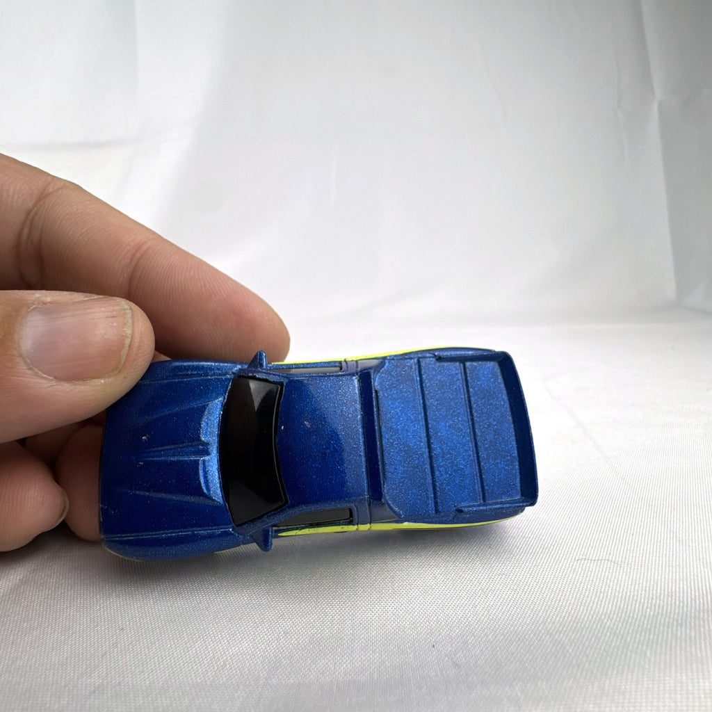 Matchbox 1995 The Buster 1:64 scale custom diecast pickup truck in metallic blue with yellow side graphics