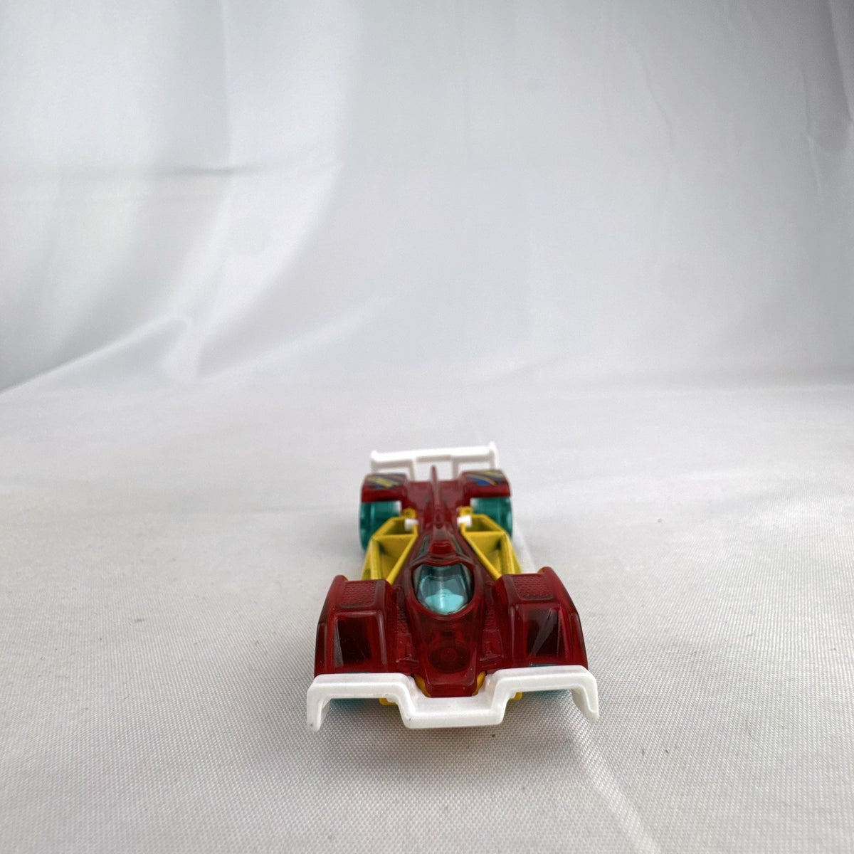 Hot Wheels Track Hammer X-Raycers diecast race car in translucent red with yellow chassis and teal wheels