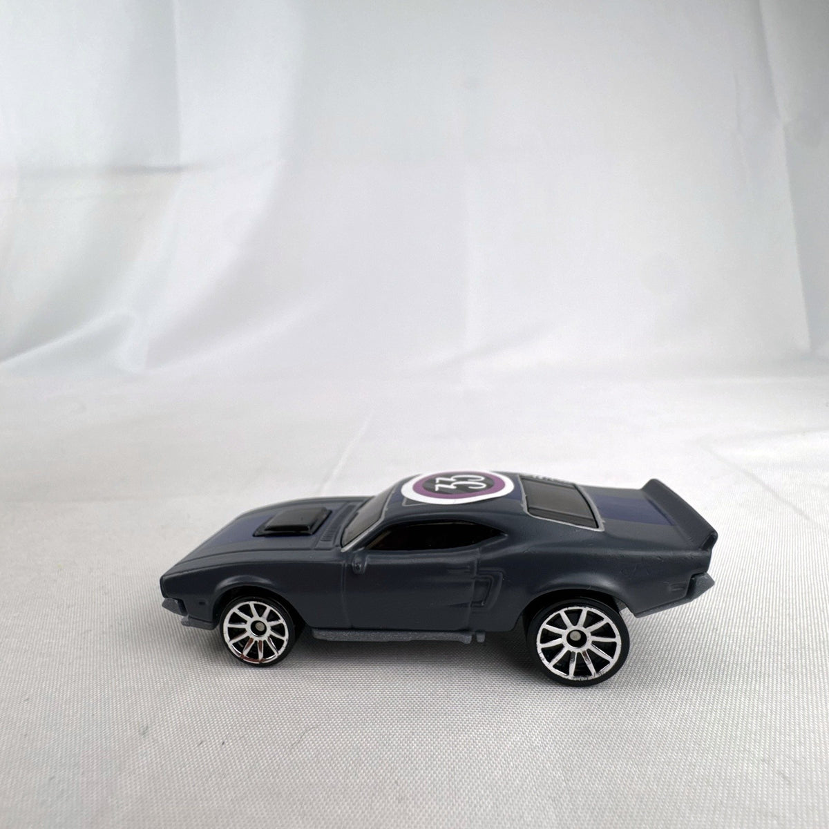 Hot Wheels 1:64 scale Ion Motors Thresher diecast car in gray with blue racing stripes from Fast and Furious Spy Racers