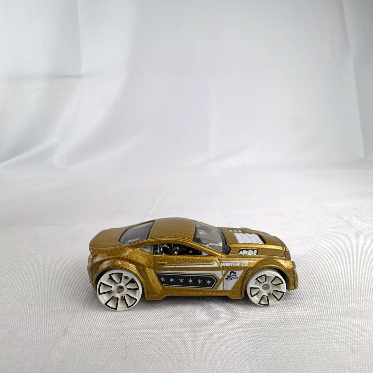 Hot Wheels Torque Twister diecast car in metallic gold with white wheels from the 2020 Winter series