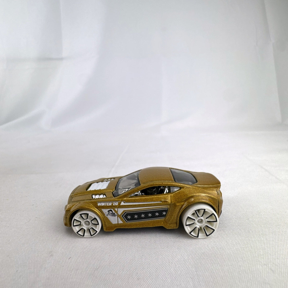Hot Wheels Torque Twister diecast car in metallic gold with white wheels from the 2020 Winter series