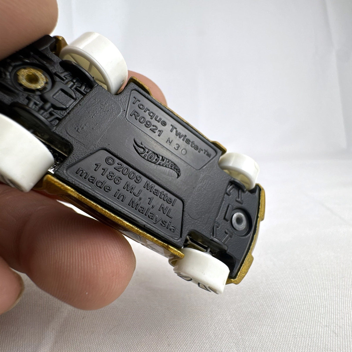 Hot Wheels Torque Twister diecast car in metallic gold with white wheels from the 2020 Winter series