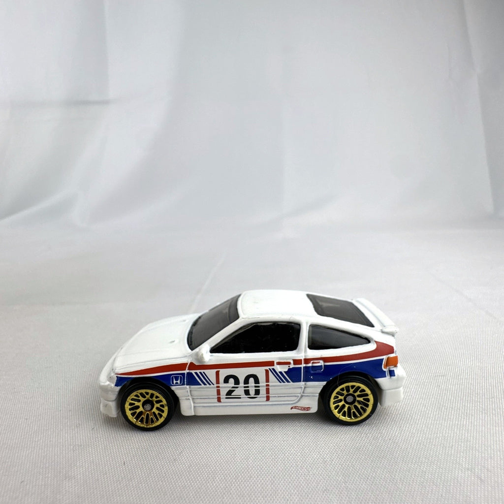 Hot Wheels 1988 Honda CRX diecast car in white HW Speed Graphics racing livery with gold wheels.