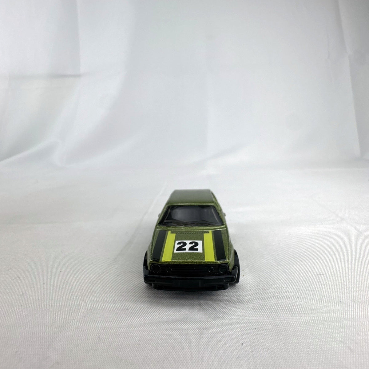 Hot Wheels 1:64 scale Volkswagen Golf Mk2 diecast car in metallic olive green with Castrol racing livery.