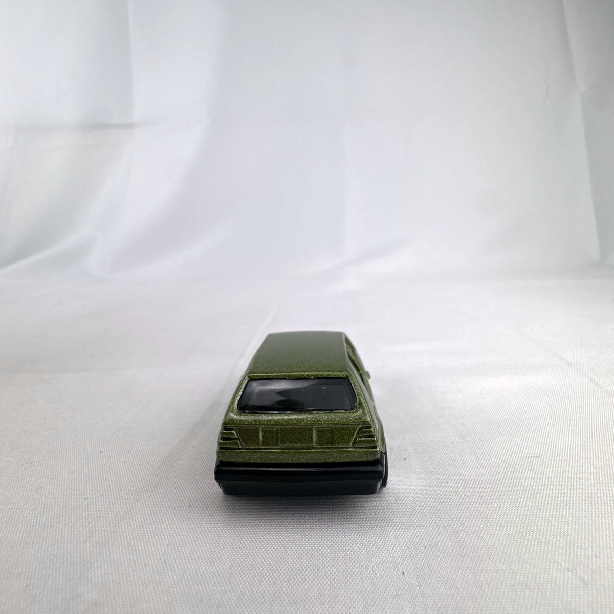 Hot Wheels 1:64 scale Volkswagen Golf Mk2 diecast car in metallic olive green with Castrol racing livery.