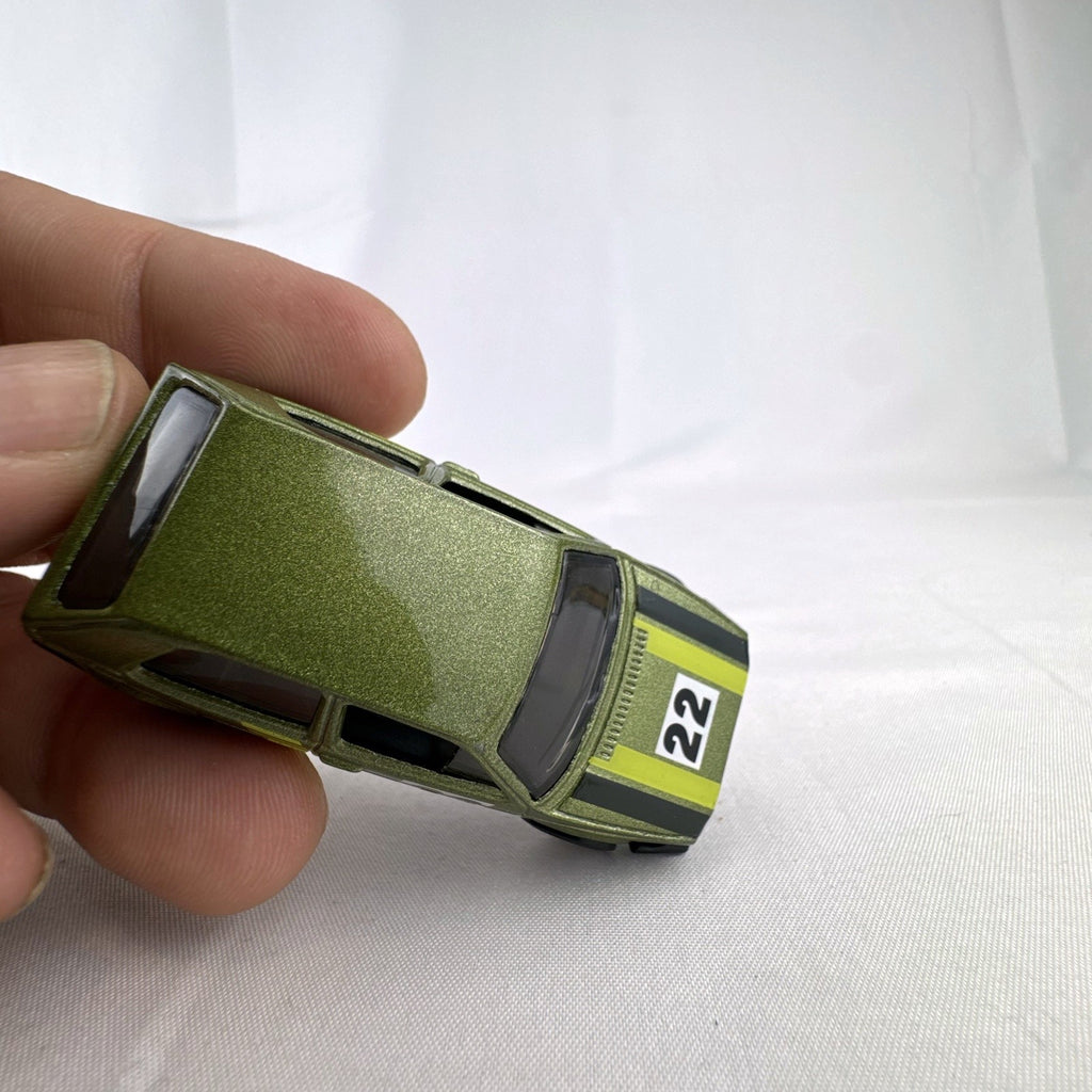 Hot Wheels 1:64 scale Volkswagen Golf Mk2 diecast car in metallic olive green with Castrol racing livery.