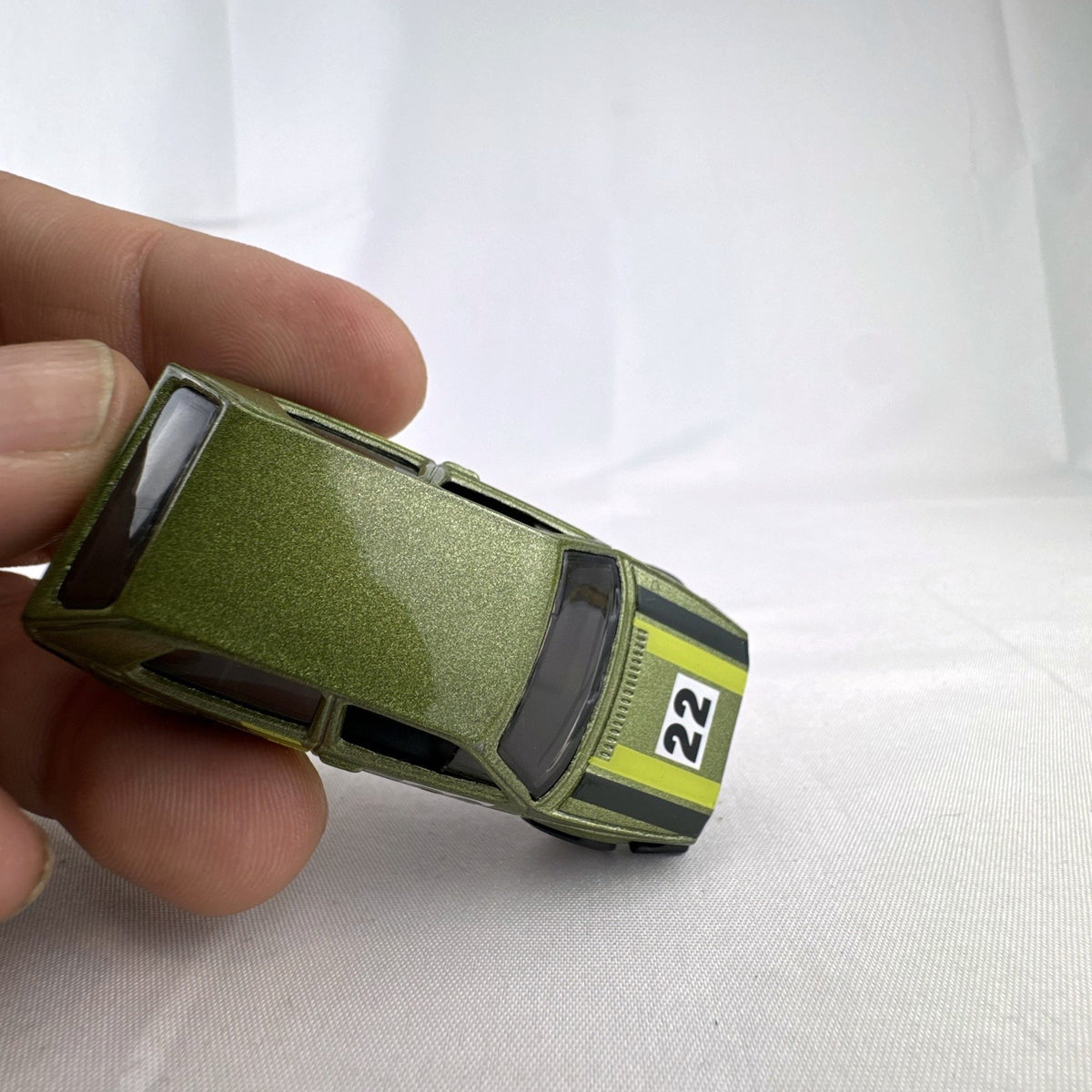 Hot Wheels 1:64 scale Volkswagen Golf Mk2 diecast car in metallic olive green with Castrol racing livery.