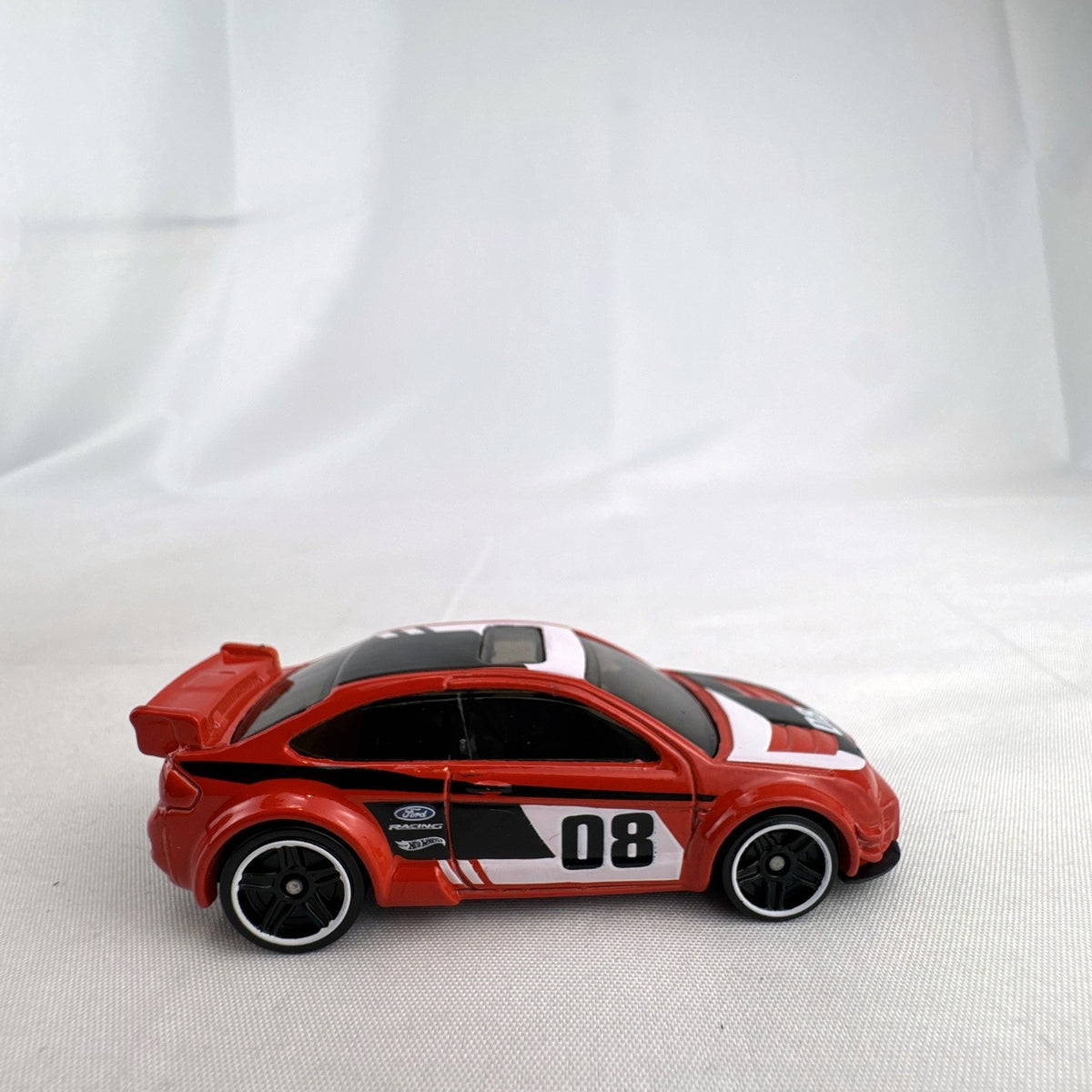 Hot Wheels 1:64 scale 2008 Ford Focus diecast rally car in red with Ford Racing graphics