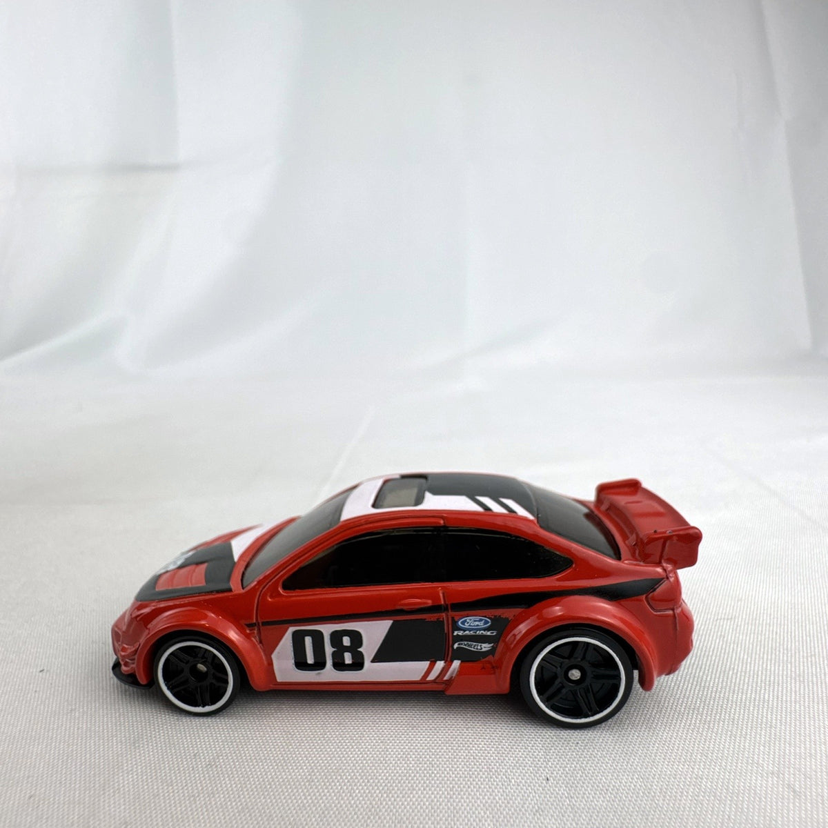 Hot Wheels 1:64 scale 2008 Ford Focus diecast rally car in red with Ford Racing graphics