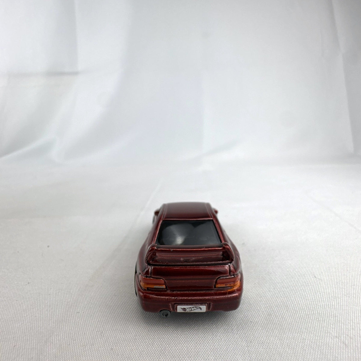 Hot Wheels 1:64 scale 1998 Subaru Impreza 22B STi-Version diecast car in dark metallic red with gold wheels