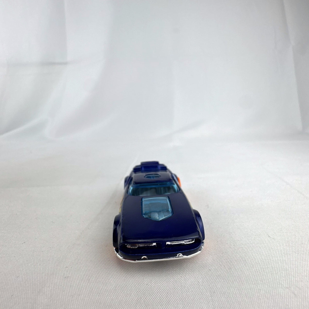 Hot Wheels Fast Fish 1:64 scale diecast car in dark blue with orange 5-spoke wheels and chrome base