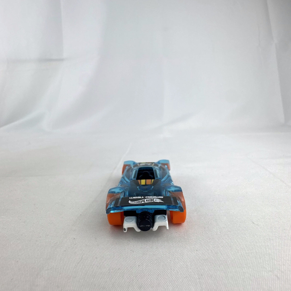 Hot Wheels Mach It Go 1:64 scale diecast race car in translucent blue with orange wheels and number 42 livery