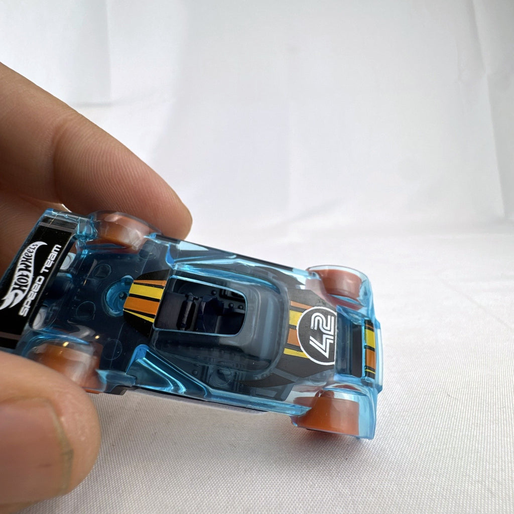 Hot Wheels Mach It Go 1:64 scale diecast race car in translucent blue with orange wheels and number 42 livery