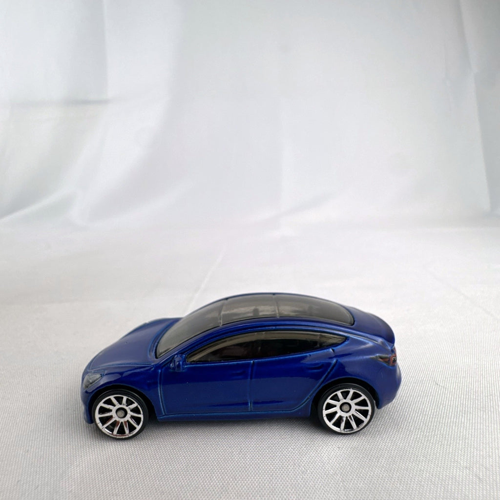 Hot Wheels 1:64 scale metallic blue Tesla Model 3 diecast car with smoke-tinted glass roof