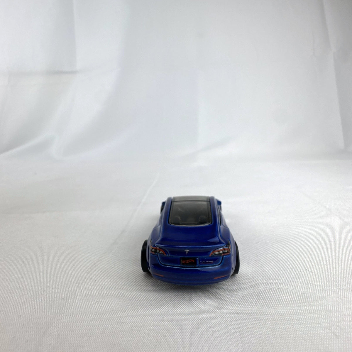 Hot Wheels 1:64 scale metallic blue Tesla Model 3 diecast car with smoke-tinted glass roof