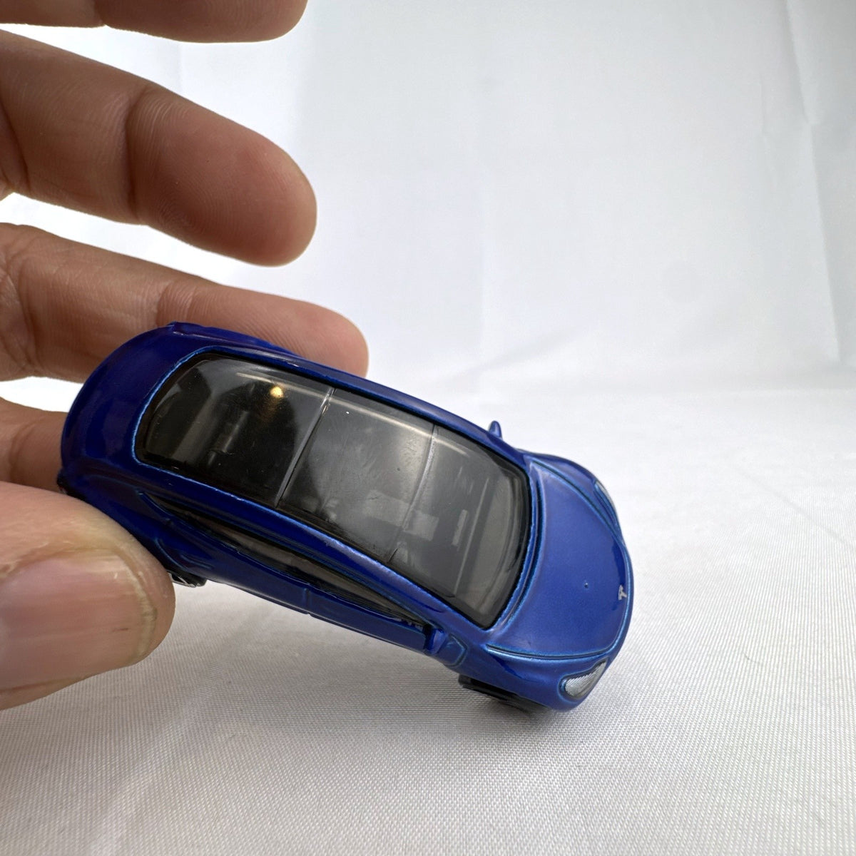 Hot Wheels 1:64 scale metallic blue Tesla Model 3 diecast car with smoke-tinted glass roof