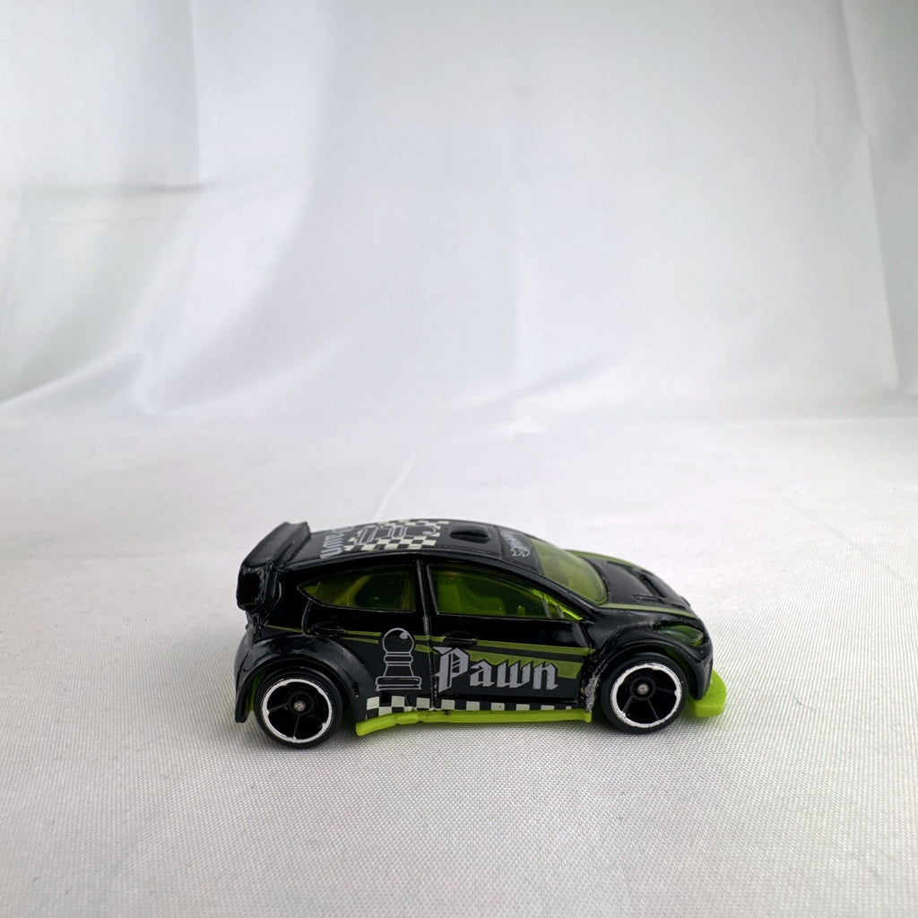Hot Wheels 1:64 scale 2012 Ford Fiesta diecast car in black with green trim and HW Checkmate pawn graphics