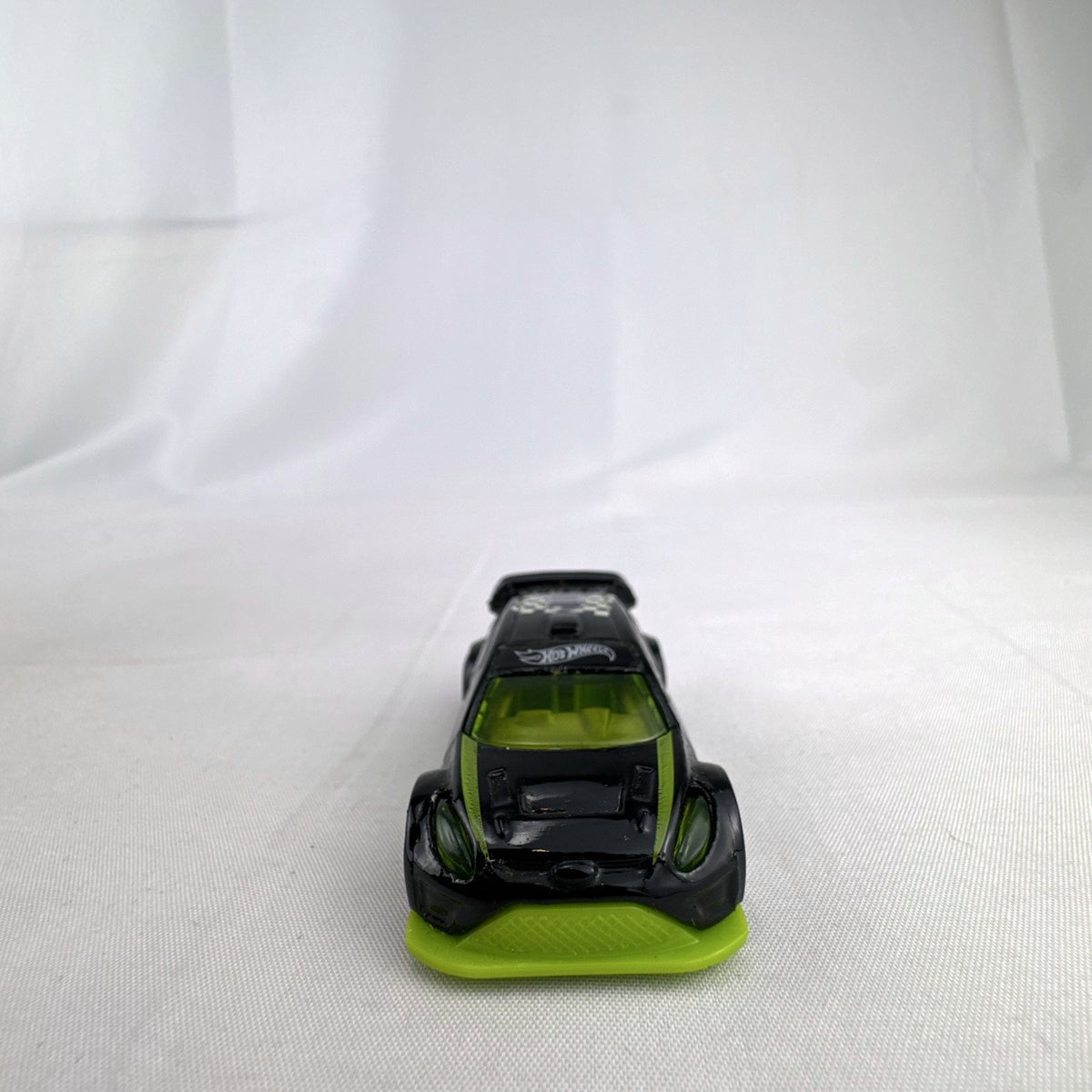 Hot Wheels 1:64 scale 2012 Ford Fiesta diecast car in black with green trim and HW Checkmate pawn graphics