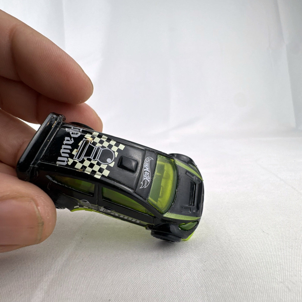 Hot Wheels 1:64 scale 2012 Ford Fiesta diecast car in black with green trim and HW Checkmate pawn graphics