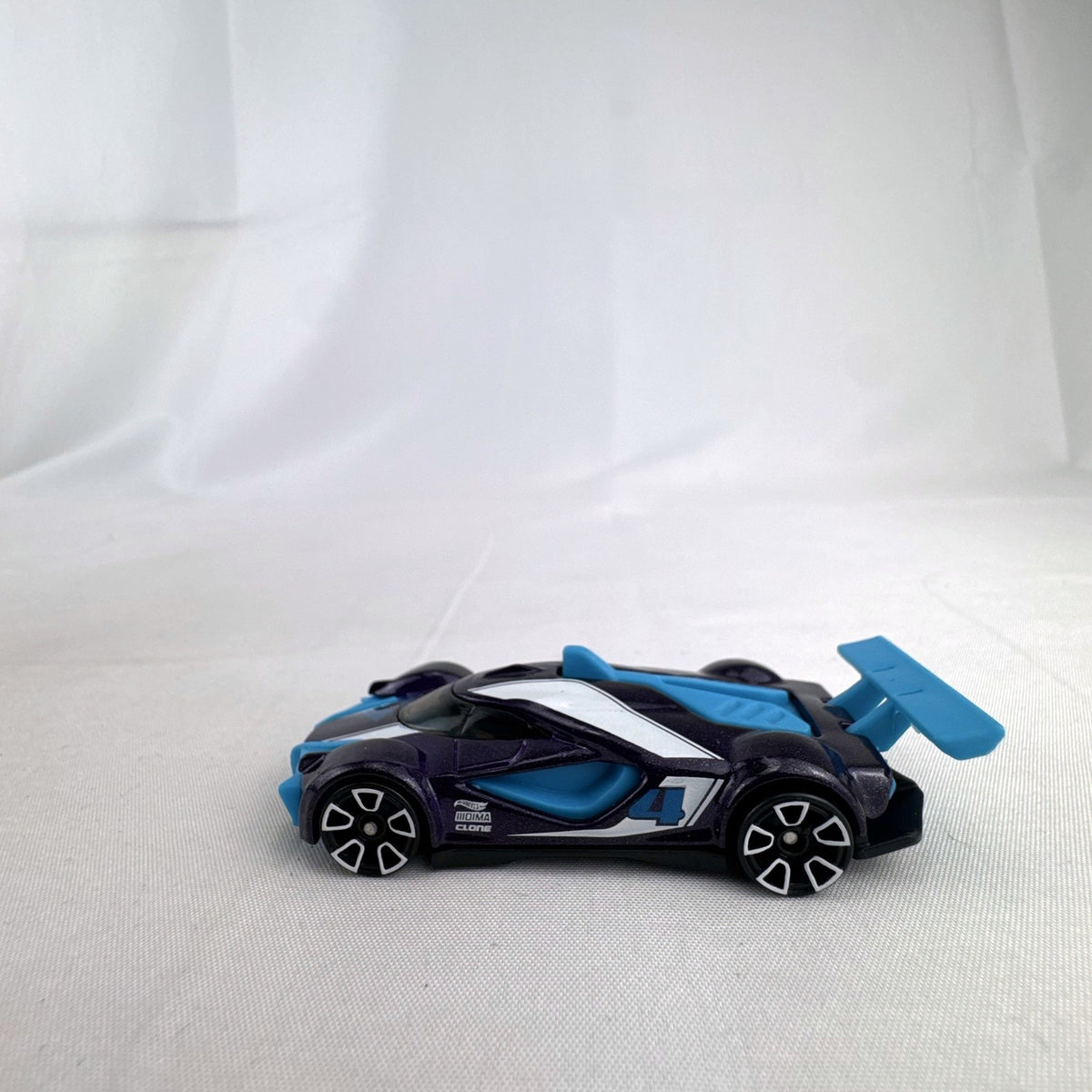 Hot Wheels Mach Speeder 1:64 scale diecast car in metallic purple with light blue accents
