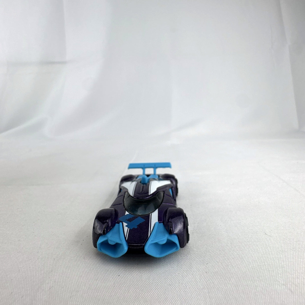 Hot Wheels Mach Speeder 1:64 scale diecast car in metallic purple with light blue accents