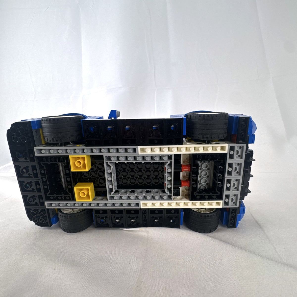 Assembled blue LEGO Creator 31070 Turbo Track Racer car with open gull-wing doors and instruction manual