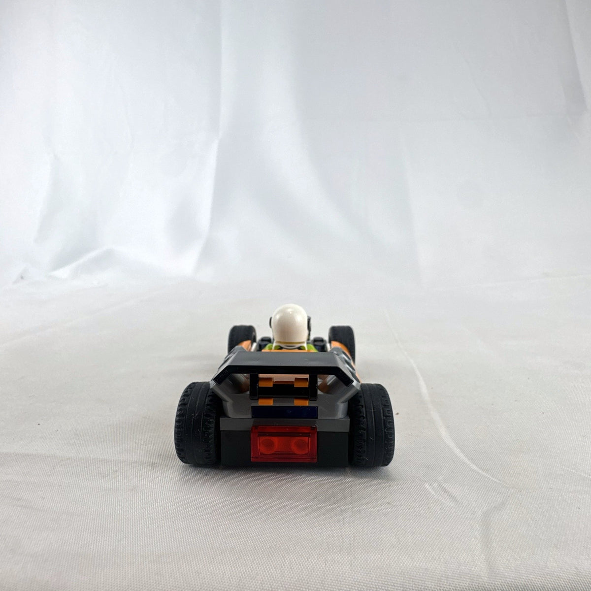 Assembled orange LEGO City 60322 Formula 1 style race car with driver minifigure