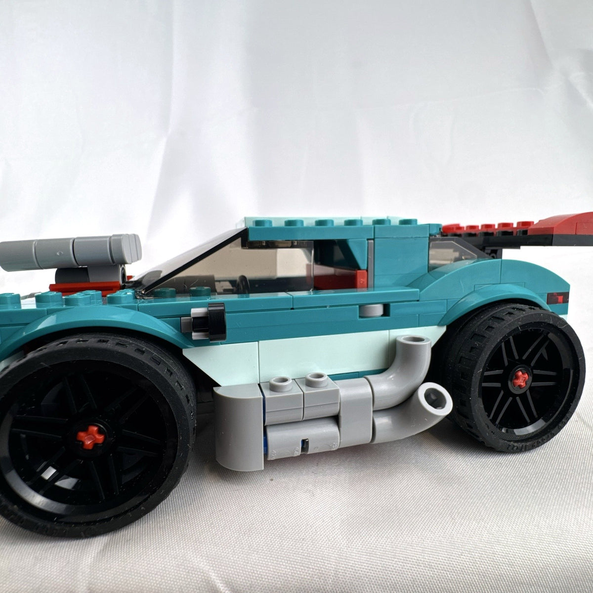 Assembled teal LEGO Creator 3-in-1 Street Racer car set 31127 with original box and instruction booklets