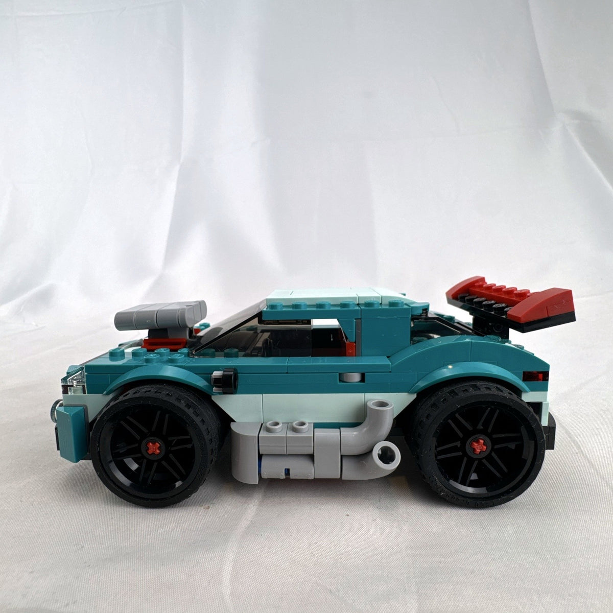 Assembled teal LEGO Creator 3-in-1 Street Racer car set 31127 with original box and instruction booklets
